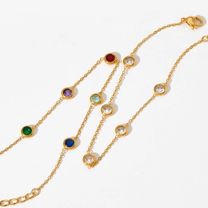 Detail of gold chain necklace featuring colorful round-cut cubic zirconia gemstones