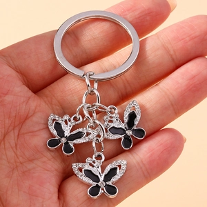 Close-up of vintage butterfly keychain with black enamel wings and clear crystal inlay