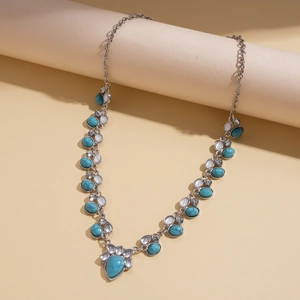 Detail of silver bohemian necklace with turquoise stones and white beads on display