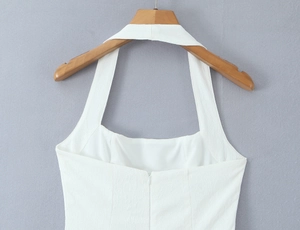 Details des weißen Neckholder-Kleids mit Ausschnitt und verdecktem Reißverschluss