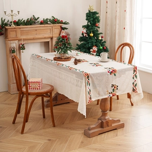 Lace Christmas tablecloth with Santa and reindeer embroidery in a cozy home setting