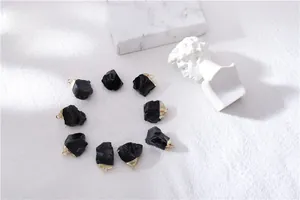 Detailed view of irregular raw black tourmaline stones with elegant gold plating