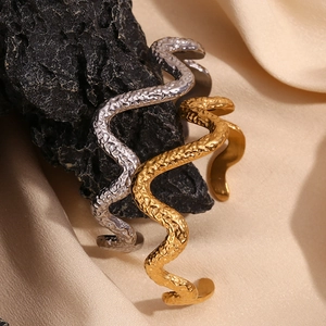 Hammered texture wavy open bangles in gold and silver finish on elegant dark stones