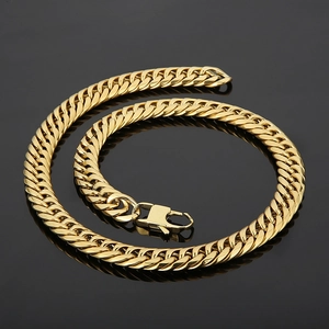Detail of golden flat link chain bracelet with lobster clasp on a black background