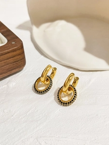 Détail de créoles plaquées or 18 carats avec breloques amovibles en cristaux pavés noirs