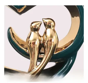 Detailopname van de smaragdgroene en gouden keramische vogels met galvanisatie