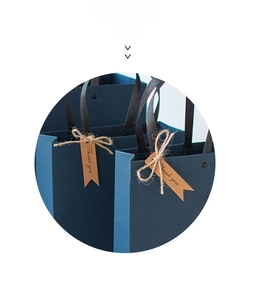 Deep blue textured gift bag with a kraft paper hang tag showing Thank You text