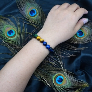 8mm and 10mm tiger eye beaded bracelet for men and women on peacock feather background