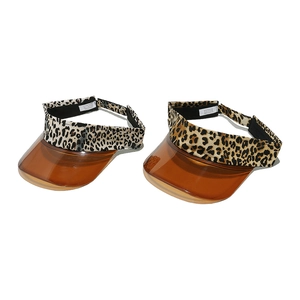 Close-up of leopard print sun visors with brown translucent brims and polyester bands