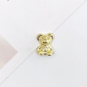 Detailed view of 3D golden metallic bear charm with bow tie for DIY craft jewelry