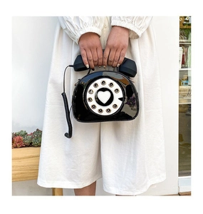 Close-up of retro telephone bag with circular dial detail and receiver handle