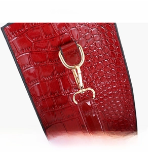 Details der roten Krokodilstruktur-Handtasche mit Goldhaken und abnehmbarem Schultergurt