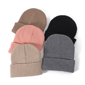 Pila de gorros de punto acanalado en negro, rosa, gris, caqui y marrón para el invierno
