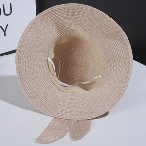 Detailed close-up of woven straw hat texture with bow decoration and windproof rope