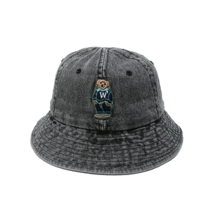 Close-up of bear embroidery and washed denim texture on a dark grey bucket hat