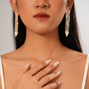 Gros plan sur les boucles d'oreilles pendantes plaquées or 18 carats à maillons polis