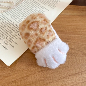 Vue détaillée d'une pince à cheveux en peluche léopard patte de chat sur fond vintage