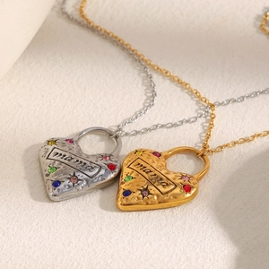 Dettaglio di ciondoli a cuore oro e argento con incisione mama e zirconi colorati incastonati