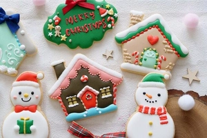 Flat lay of snowman and gingerbread house cookies with Merry Christmas frosting