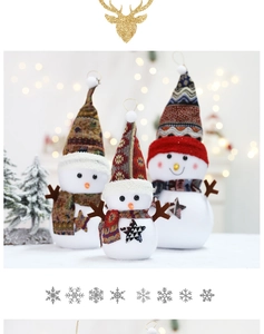 Three plush Christmas snowmen with ethnic hats and stars in festive holiday setting