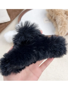 Macro view of a large black faux fur hair claw clip showcasing its soft fluffy texture