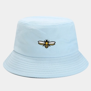 Detail of light blue bucket hat featuring fine bee embroidery and breathable cotton fabric