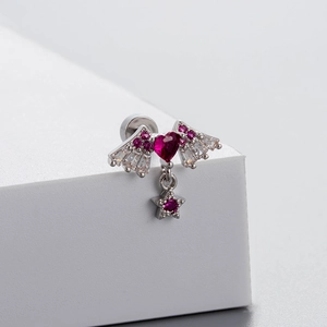 Silver winged heart stud earring with red zircon stone and star pendant on display