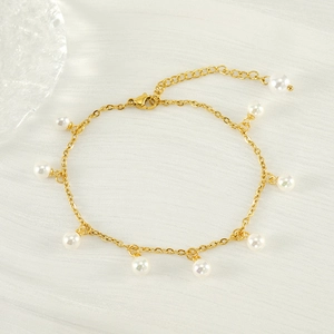 Detail of 18K gold titanium anklet featuring white round pearl tassels and lobster clasp