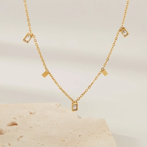 Minimalist gold necklace featuring rectangular pendants with inlaid cubic zirconia crystals