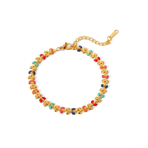 Detailed shot of golden leaf bracelet featuring colorful enamel accents and lobster clasp
