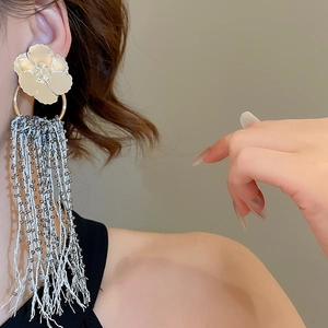 Close-up of elegant flower tassel earrings with white petals and silver beaded fringe