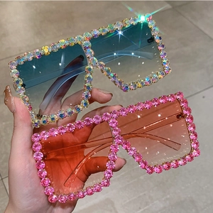 Detailed view of oversized sunglasses with gradient lenses and vibrant rhinestone encrusted frames