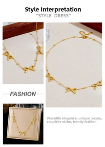 Close-up of gold-plated butterfly pendants and bead chain detail on a steel necklace