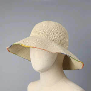 Close-up of handmade straw hat featuring rainbow stitched edges and woven texture
