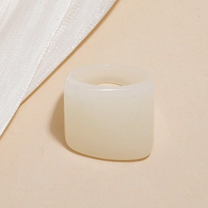 Close-up of a minimalist cream-colored resin ring with a square-shaped design