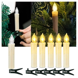 Detail of hand placing LED taper candle with faux drip effect on Christmas tree branch