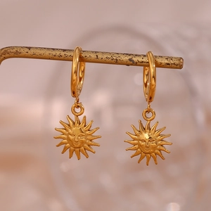 Detail of golden sun face pendant on a vintage metal stand with soft bokeh background