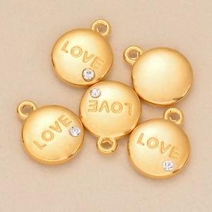 Vue détaillée de pendentifs LOVE dorés avec incrustation de strass étincelants