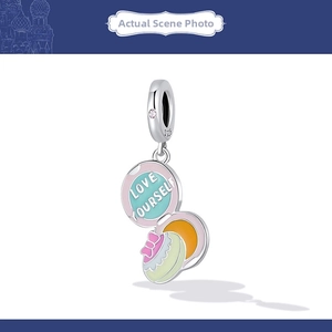 Macro shot of S925 silver charm with Love Yourself engraving and pink cubic zirconia