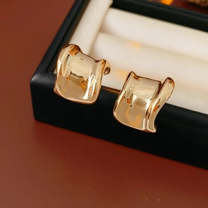 Nahaufnahme der goldenen Wellenohrringe in einer schwarzen Schmuckbox mit Metallglanz