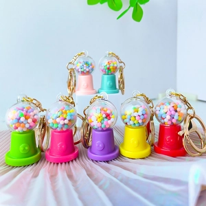 Macro shot of colorful mini candy machine keychains with golden metal lobster clasps