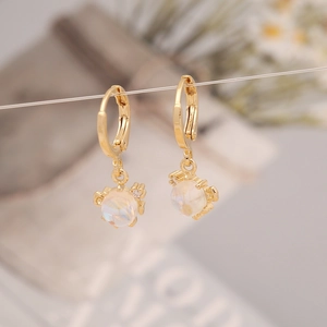 Macro shot of gold-plated marine earrings featuring a translucent opal-like stone and cubic zirconia