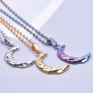 Close-up of stainless steel crescent moon pendants in gold, silver, and rainbow finishes