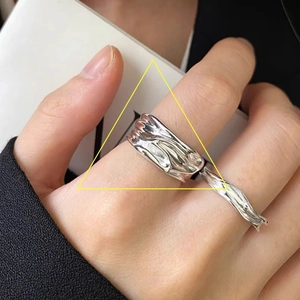 Detailed macro view of 925 silver irregular liquid metal texture open ring on finger