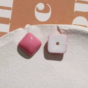 Macro detail of macaron pink resin heart and square DIY beads with smooth glossy finish