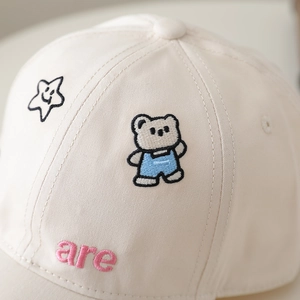 Detail of baby bear and star embroidery on creamy white cotton kids baseball cap