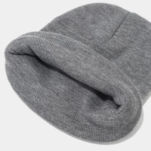 Close-up of dark grey ribbed knit beanie showing thick warm fabric texture and weave detail