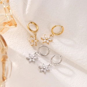 Elegant gold and silver sunflower earrings with white crystals on white fabric