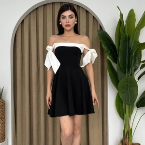 Detail of elegant black and white off-shoulder dress with large white shoulder bows