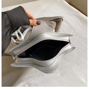 Detail view of the silver star-shaped handbag interior with black fabric and zip pocket